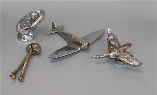 Two chrome car mascots, a skull nut cracker and a model plane